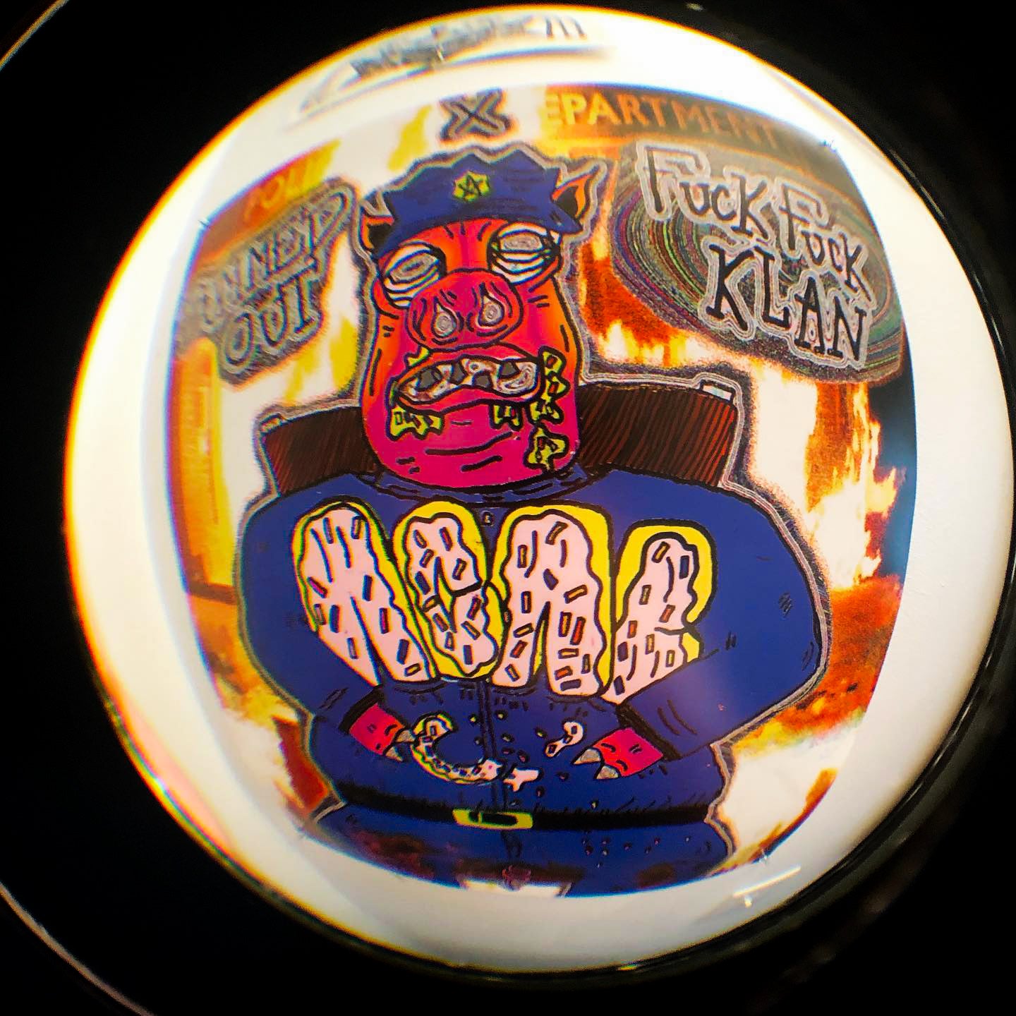 Colorful graphic with a devil-like pig police officer and text over a burning police station