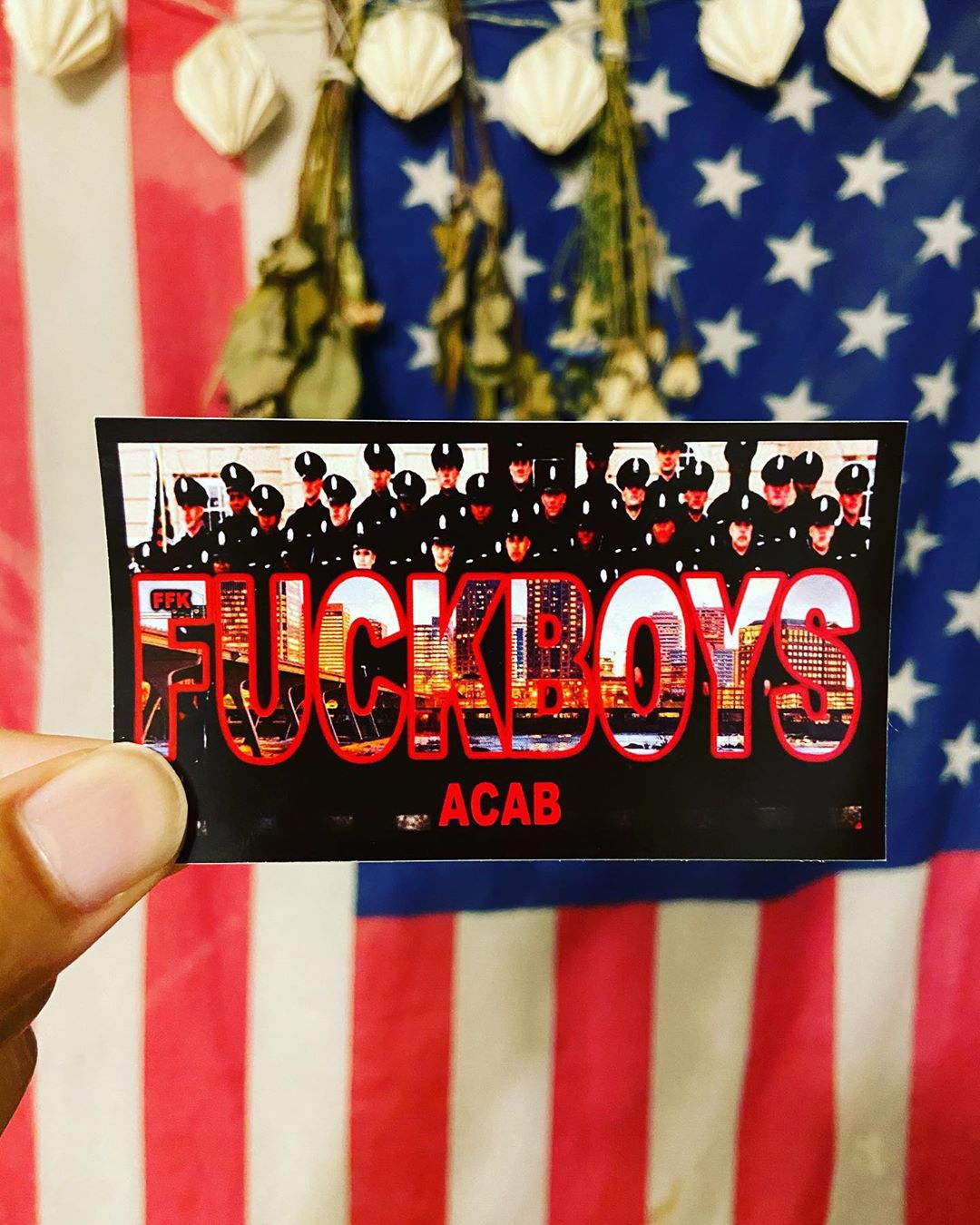 FFK ACAB Sticker with text and images held in front of an American flag